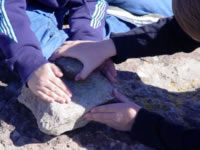 schoolkids try a metate